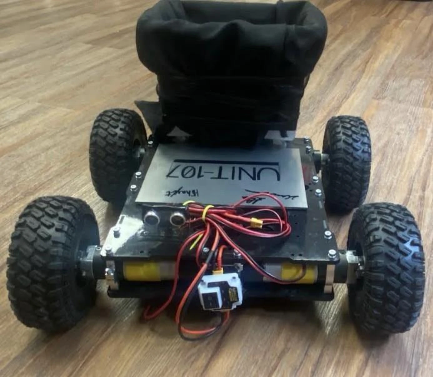 ECO-Sweep UNIT-107, a black four-wheel rover with a fabric collection bin.
